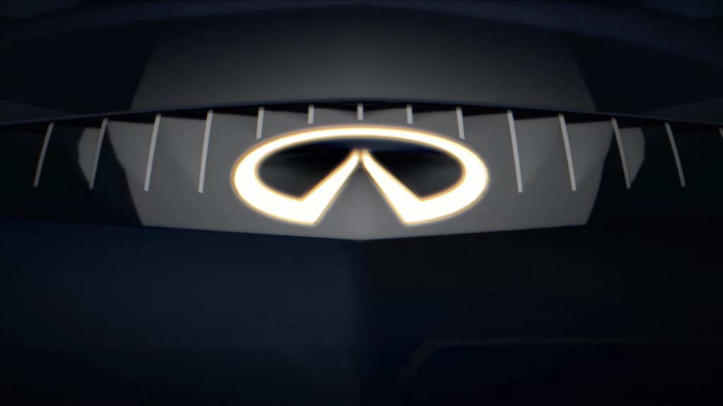 Close-up of an illuminated Infiniti logo set against a dark grille