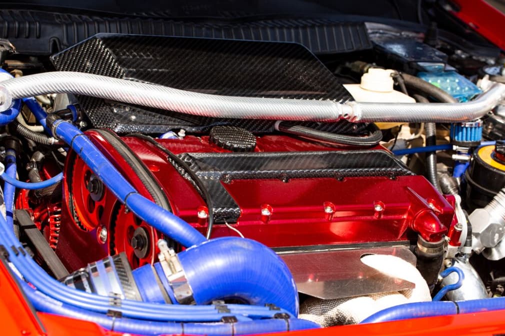 A high-performance red engine with carbon fiber and blue hoses